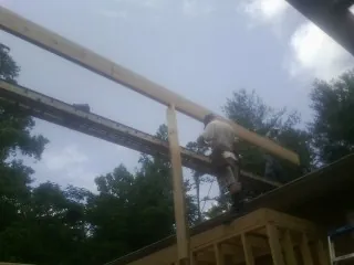 Carpenter setting a ridge beam over a new addition frame — Ice Dam Removal by Roofing Brothers in Palo Cedro