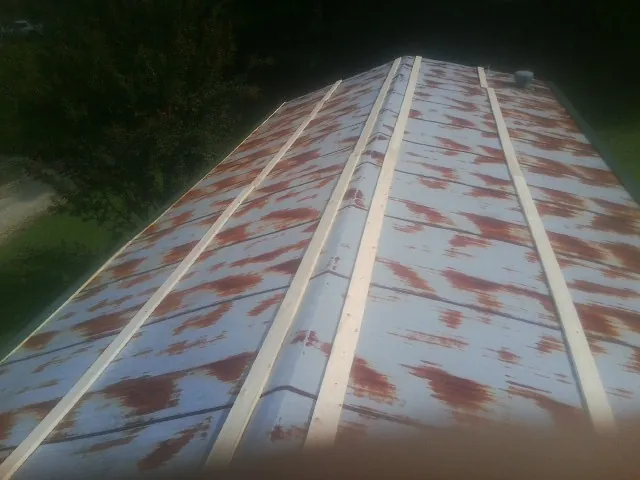 Rusted metal roof panels with new wood purlins before replacement — Storm Damage Roof Repair in Palo Cedro by Roofing Brothers
