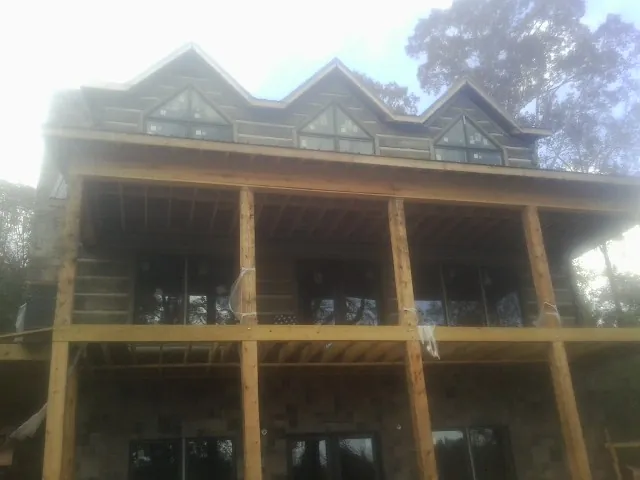 Dormers and porch framing on a large log home under construction — Roof Coating work by our crew in Palo Cedro
