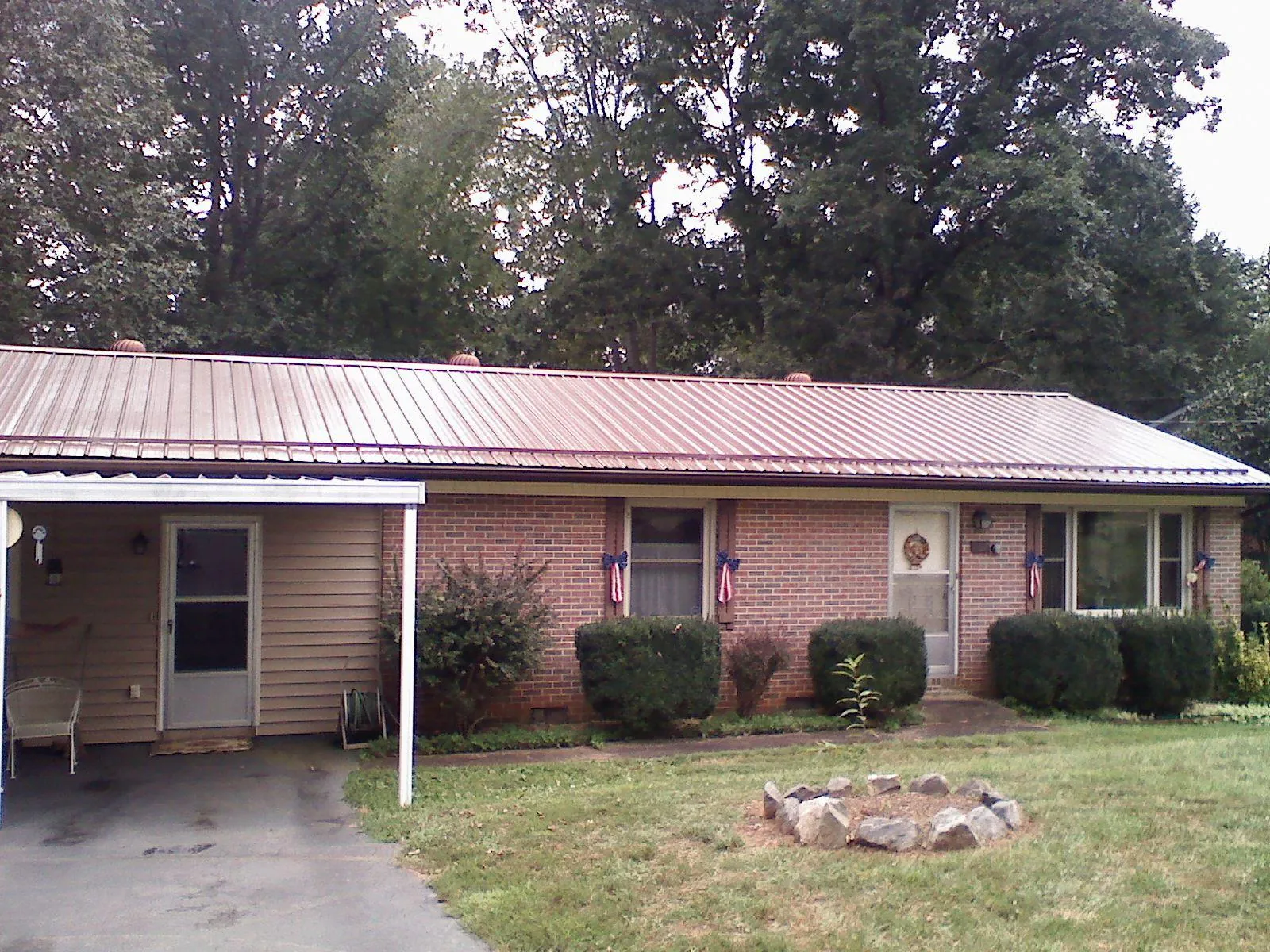 Bronze metal roof and carport on a brick ranch home — Roof Repair work by our crew in Palo Cedro